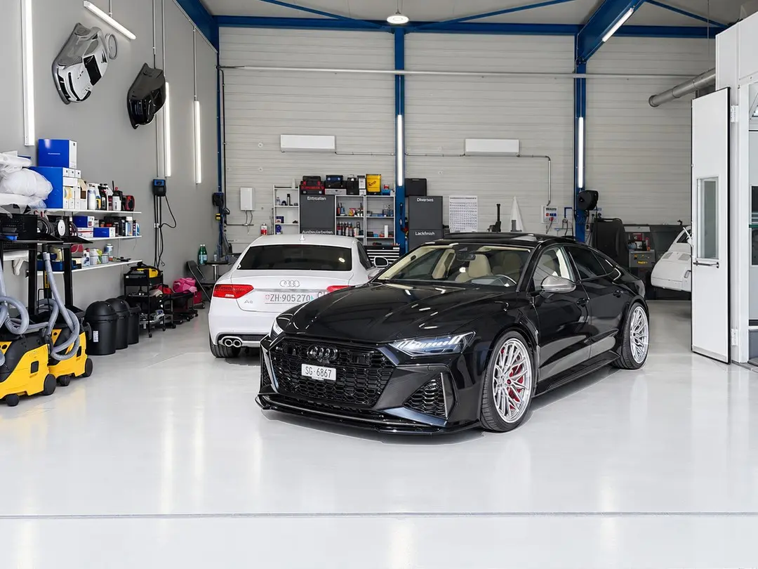 Schwarzer Audi RS7 und weisser Audi A5 in der Werkstatthalle