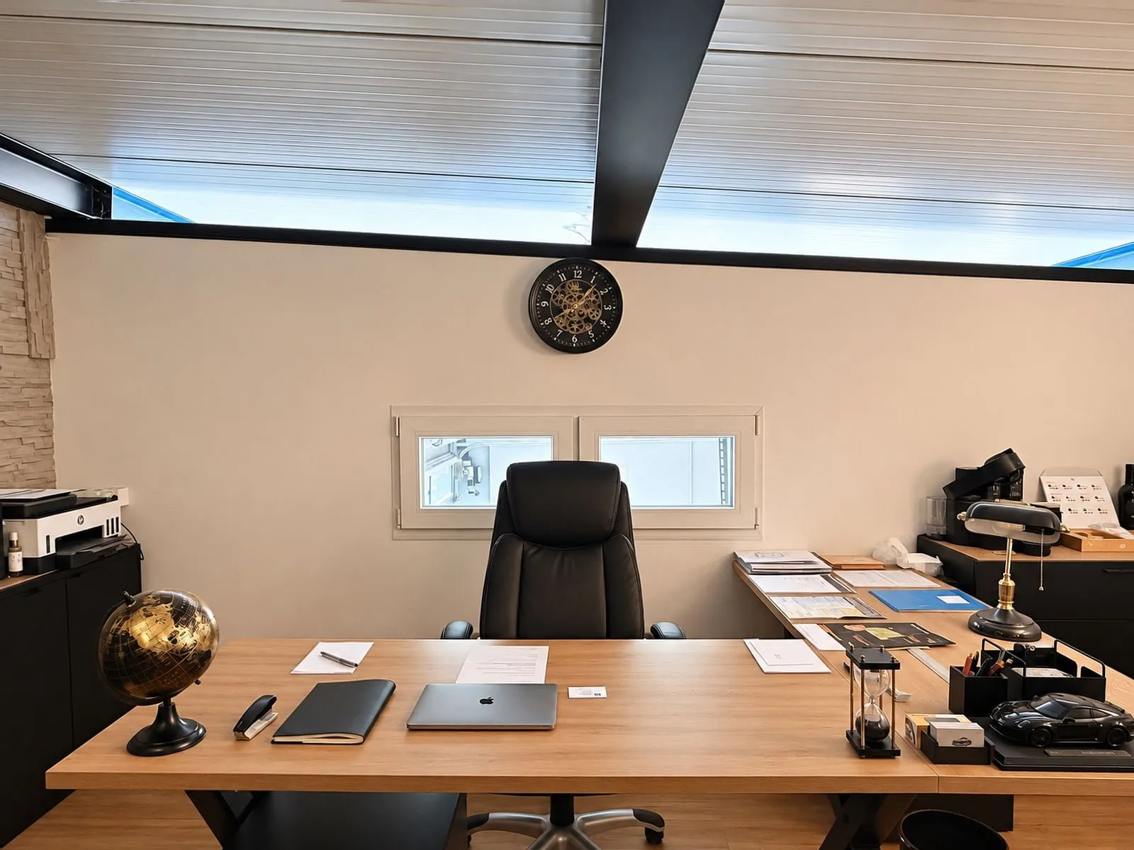 Schreibtisch im Büro mit Laptop, Unterlagen und einem Globus